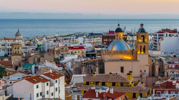 Foto paisaje urbano de alicante al atardecer mostrando la catedral con el mar al fondo