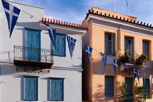 Paisaje urbano de ciudad mediterránea con casas sencillas y guirnalda de banderas griegas, Nauplia, Grecia