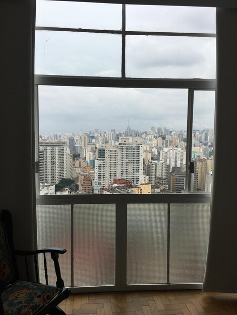 Foto paisaje urbano contra el cielo visto a través de la ventana