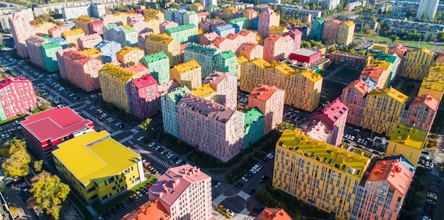 Paisaje urbano de edificios coloridos. Vista aérea de los coloridos edificios de la ciudad europea en la luz del sol de la mañana. Paisaje urbano con casas multicolores, coches en la calle en Kiev, Ucrania