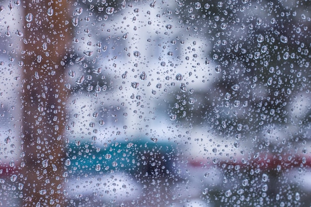 Paisaje urbano, fondo borroso detrás de vidrio húmedo con gotas de lluvia, estaciones de otoño