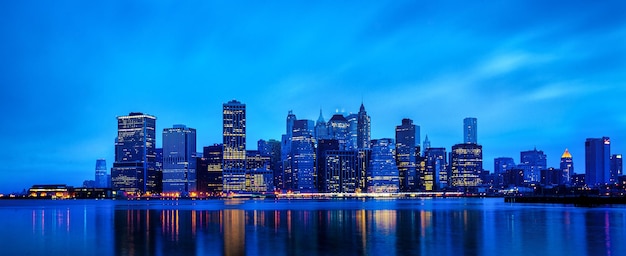 Foto paisaje urbano iluminado de brooklyn con reflejo en el agua