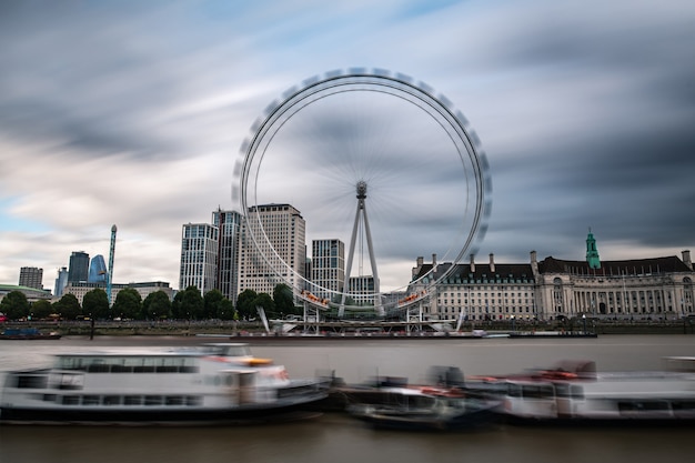 Paisaje urbano de Londres por el río Támesis con la Rueda del Milenio en un lluvioso día de verano gris.