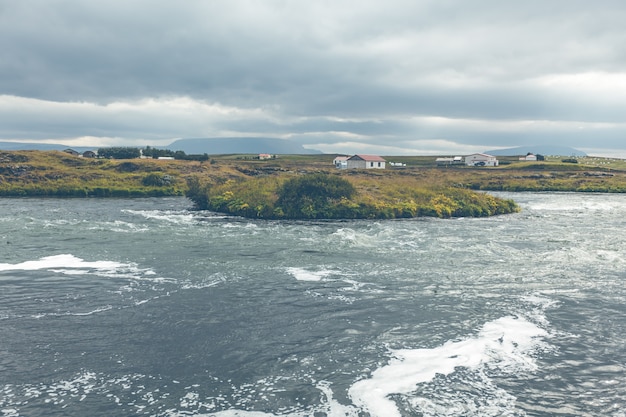 Paisaje de verano de Islandia con río embravecido en tiempo nublado