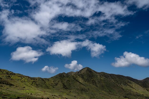 Paisaje de verano de montañas verdes y cielo azul con nubes blancas Colinas cubiertas de hierba en un día soleado