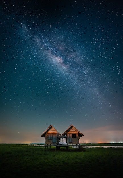 Paisaje de la vía láctea sobre la casa gemela abandonada cerca de Chalerm Phra Kiat road en Thale Noi, Phatthalung, Tailandia