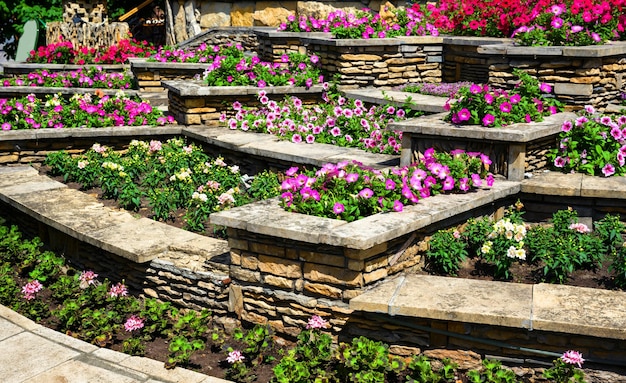 Paisajismo con muros de contención y macizos de flores en el patio trasero de una casa residencial