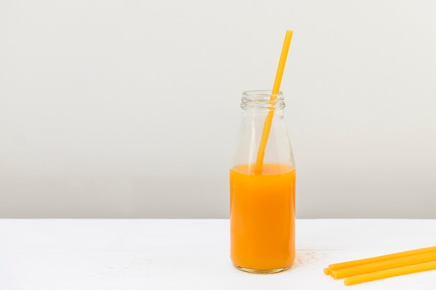 Paja de pasta en una botella de vidrio con concepto de desperdicio cero de jugo de durazno