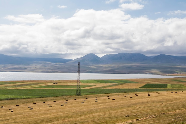 Pajares y rollos, agricultura en Georgia, heno seco y paisaje de montaña con lago Faravani