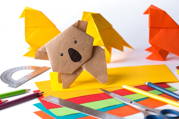 Foto pájaro de origami y koala hechos de papel de colores papel regla lápices cuchillo interesante pasatiempo