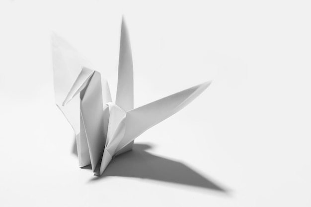 Un pájaro de papel origami blanco sobre un fondo blanco