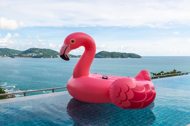 Pájaro de plástico rosa flotante en la piscina del resort