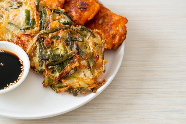 Pajeon o panqueque coreano y panqueque Kimchi coreano o Kimchijeon sobre fondo blanco