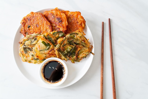 Pajeon o panqueque coreano y panqueque Kimchi coreano o Kimchijeon sobre fondo blanco