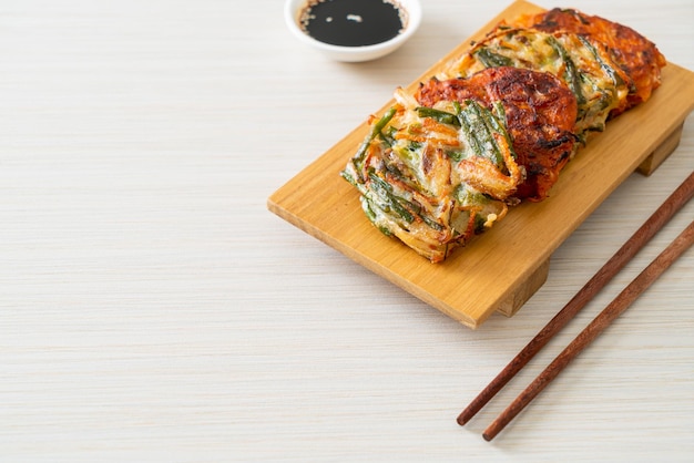 Pajeon o panqueque coreano y panqueque Kimchi coreano o Kimchijeon sobre fondo blanco