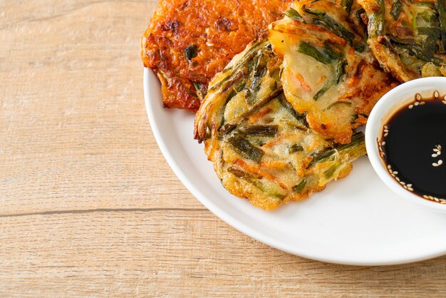 Pajeon o panqueque coreano y panqueque Kimchi coreano o Kimchijeon sobre fondo blanco