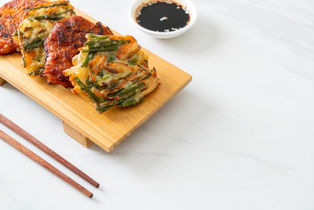 Pajeon o panqueque coreano y panqueque Kimchi coreano o Kimchijeon sobre fondo blanco