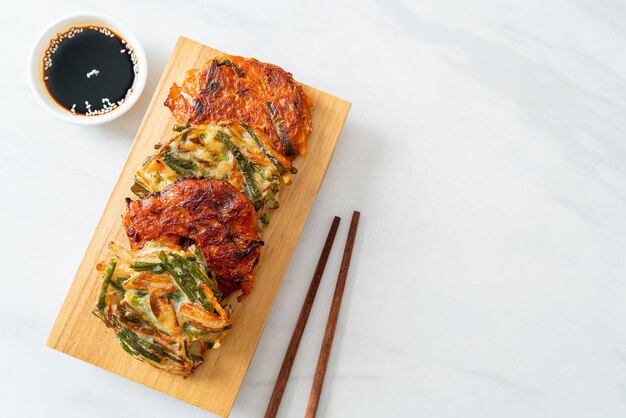 Foto pajeon o panqueque coreano y panqueque kimchi coreano o kimchijeon sobre fondo blanco