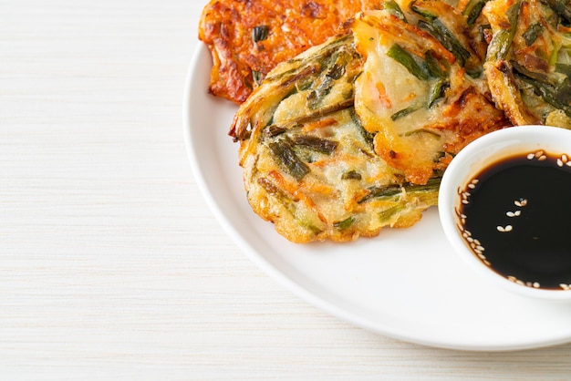 Pajeon o panqueque coreano y panqueque Kimchi coreano o Kimchijeon sobre fondo blanco