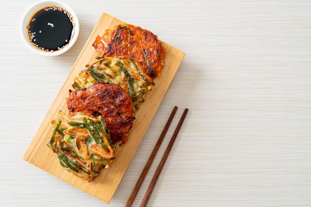 Pajeon o panqueque coreano y panqueque Kimchi coreano o Kimchijeon sobre fondo blanco