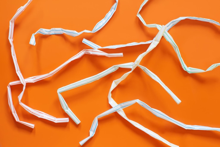 Foto las pajitas de plástico usadas en el fondo naranja