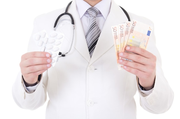 Paket von Pillen und Euro-Banknoten in den Händen des männlichen Arztes isoliert auf weißem Hintergrund