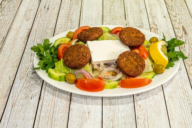 Foto pakistanisches kebab-restaurantmenü mit frischem käse, falafelsalat, grünen oliven, gehackten frischen gurken, tomaten, roten zwiebeln und olivenöl