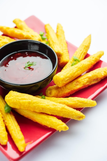 Pakoda pakora de milho frito crocante ou bolinhos de milho bebê servidos com ketchup comida indiana