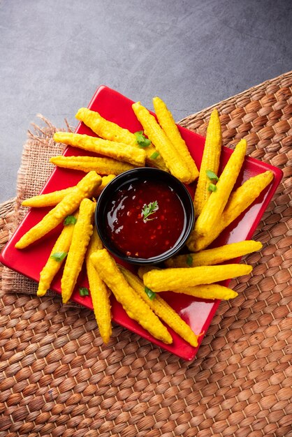 Foto pakoda pakora de milho frito crocante ou bolinhos de milho bebê servidos com ketchup comida indiana