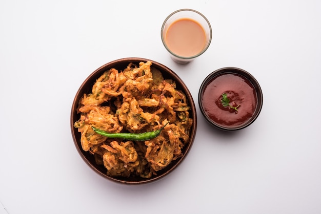 Pakora de cebolla frita o Pyaj Pakoda, también conocida como Crispy Kanda bhaji / Bhajji / bajji, el refrigerio favorito de la hora del té indio durante la temporada de lluvias. servido con salsa de tomate