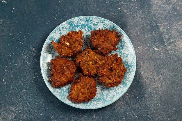 Pakora o pakoda de verduras picantes indias servidas en un plato aislado en la vista superior de la mesa