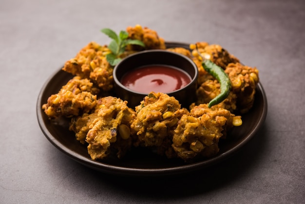 Pakora ou pakoda de milho crocante, bhajji, Bhaji, bajji ou pattice. servido com ketchup de tomate