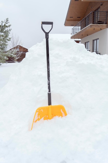 Una pala amarilla de pie en la nieve.