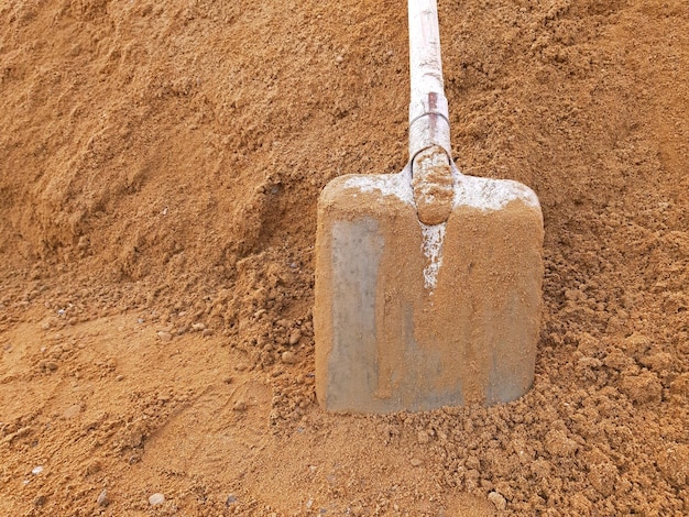 Foto una pala en arena de construcción con espacio de copia.