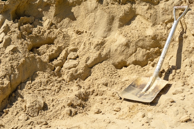 Foto pala de arena en el sitio de construcción con espacio de copia