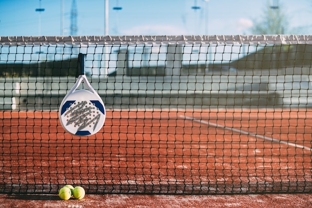 Foto pala de padel colgada en la red