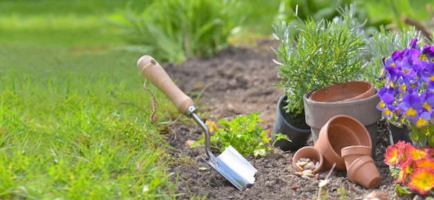 Foto pala plantada en el suelo de un jardín junto a macetas