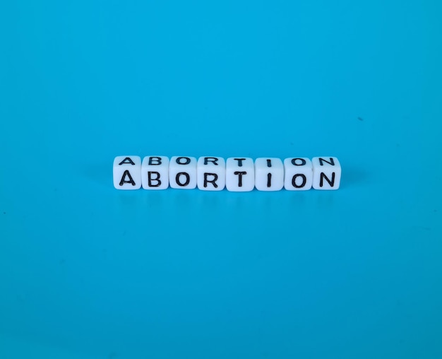 Foto palabra de aborto en cubos de madera en concepto de fondo azul