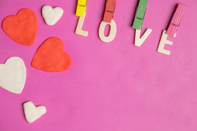 Foto palabra amor en corazones rojos sobre fondo rosa, icono de amor, día de san valentín, concepto de relaciones