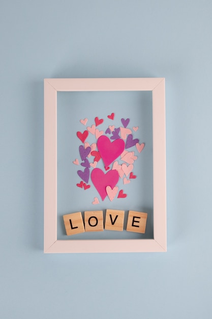 Foto palabra amor en cubos de madera y corazones en mesa azul