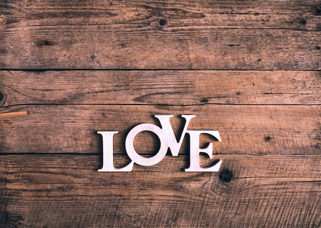 Palabra "amor" en una vieja tabla de madera. Día de San Valentín