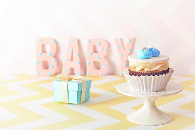 Palabra bebé con cupcake sobre fondo brillante