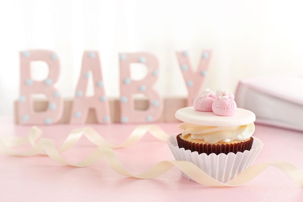 Palabra bebé con cupcake sobre fondo brillante