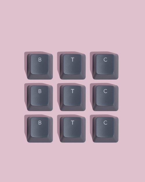 Foto la palabra btc se presenta a partir de teclas de teclado gris sobre un patrón de fondo rosa