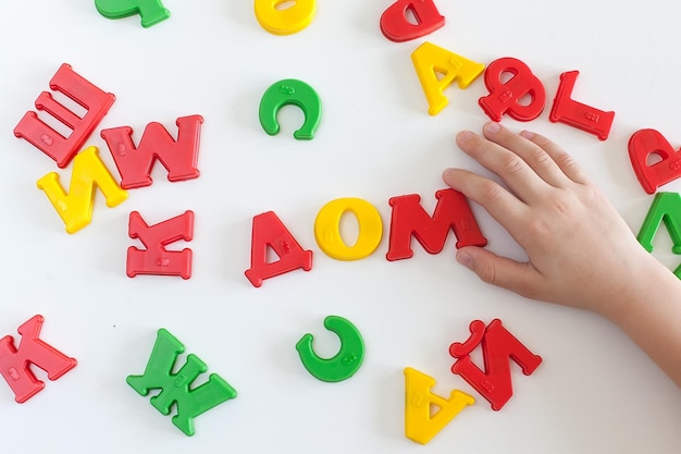 Foto la palabra casa está hecha de letras de plástico sobre un fondo blanco letras de diferentes colores