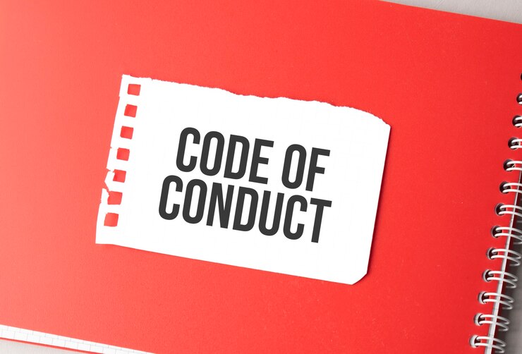 Foto la palabra código de conducta en papel rasgado en el bloc de notas rojo.