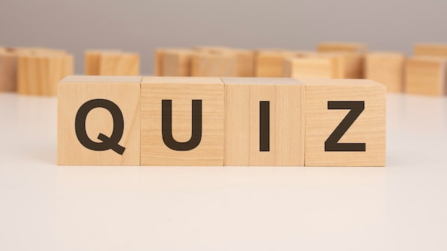 palabra corta letras en inglés con texto QUIZ en un pequeño cubo de madera con fondo blanco copia espacio enfoque de selección de concepto