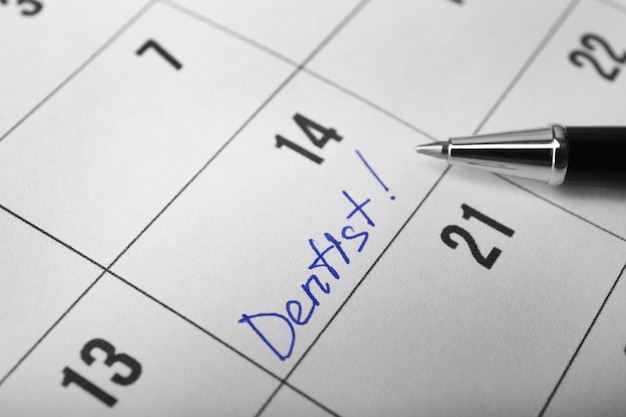 Palabra DENTISTA en primer plano de calendario y pluma