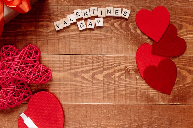 Foto la palabra día de san valentín. amor en bloques de madera sobre fondo natural. tema de amor, corazón y regalo.