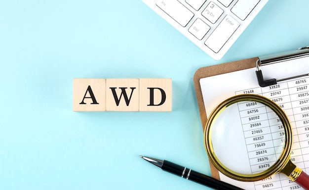 Palabra de diseño web adaptativo AWD en cubos de madera sobre un fondo azul con gráfico y teclado